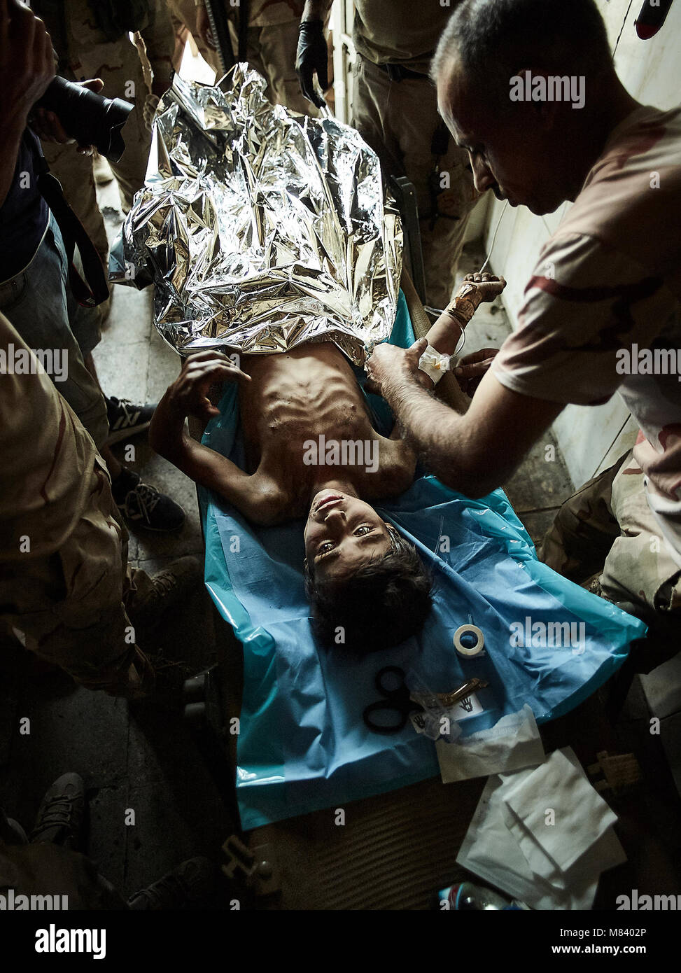 Eine verletzte Yeziden Junge ist durch Ärzte nach aus islamischen Staat Entführern gerettet werden überprüft. Die Stadt Mosul im Nordirak hat unter islamischen Staat militanten wurde für 3 Jahre, seit Juni 2014. Im Juli 2017 die Streitkräfte der Koalition geführt von der irakischen Armee hat endlich befreit die Stadt aus der Hand von Terroristen. Stockfoto