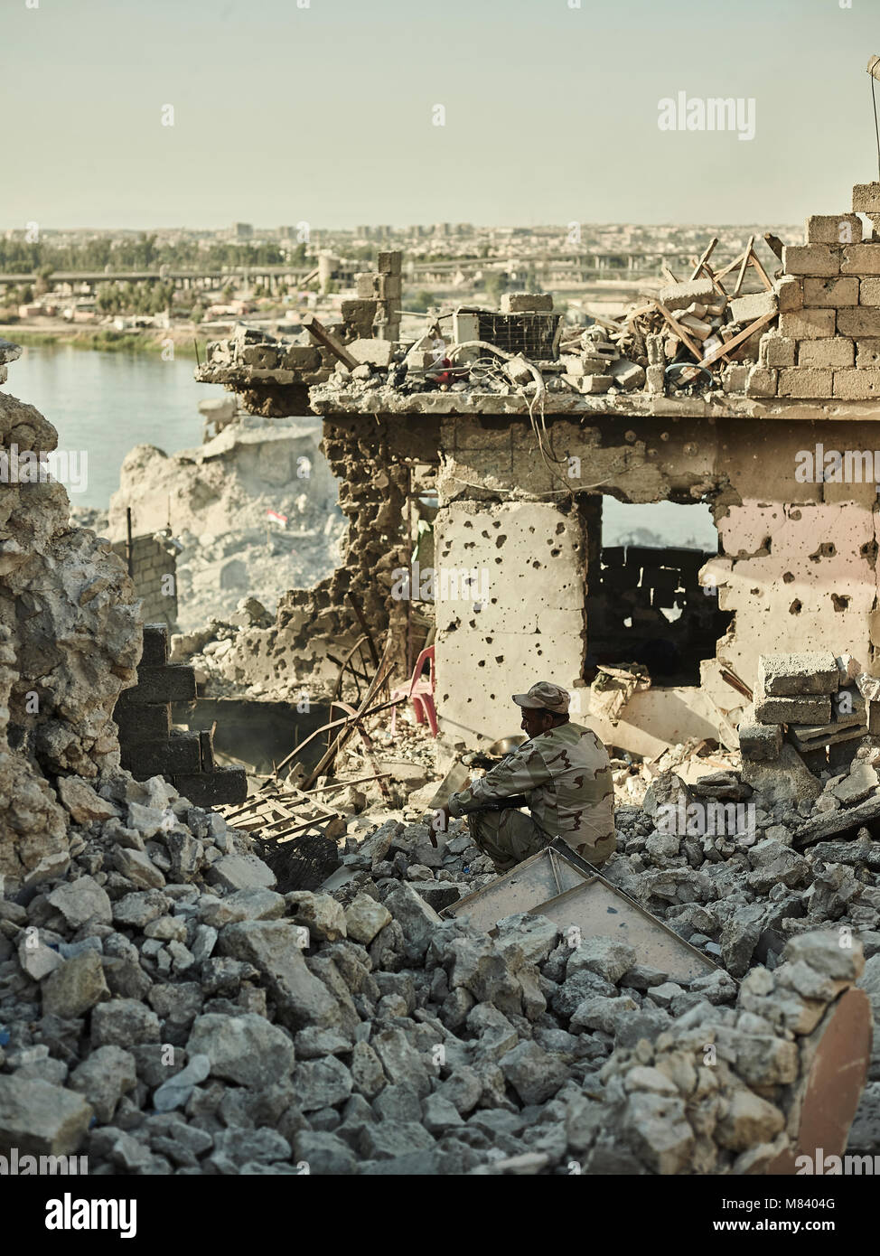 Ein irakischer Soldat sieht an an der Zerstörung entlang des Tigris. Die Stadt Mosul im Nordirak hat unter islamischen Staat militanten wurde für 3 Jahre, seit Juni 2014. Im Juli 2017 die Streitkräfte der Koalition geführt von der irakischen Armee hat endlich befreit die Stadt aus der Hand von Terroristen. Stockfoto