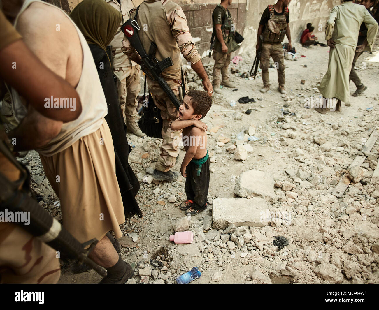 Ein Kind schreit für seine Eltern an einem Checkpoint für intern Vertriebene in der alten Stadt von West Mosul. Die Stadt Mosul im Nordirak hat unter islamischen Staat militanten wurde für 3 Jahre, seit Juni 2014. Im Juli 2017 die Streitkräfte der Koalition geführt von der irakischen Armee hat endlich befreit die Stadt aus der Hand von Terroristen. Stockfoto