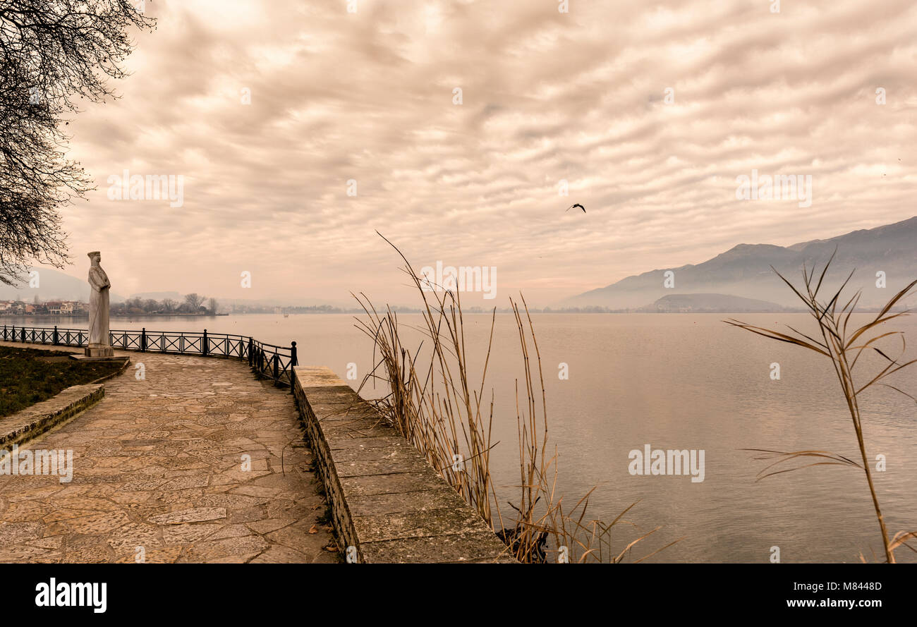Nebligen Nachmittag auf See Pamvotis. Leere Straße für Fußgänger und Fahrräder. Ioannina, Griechenland. Sepia Ton Stockfoto