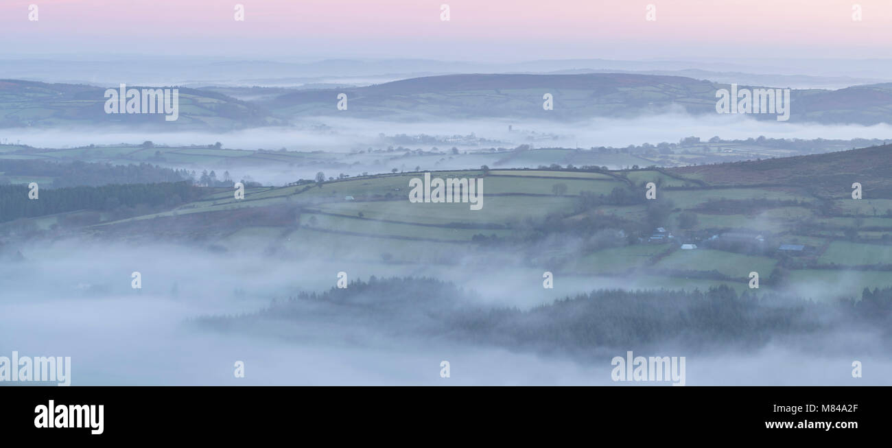 Die hügelige Landschaft in der Morgendämmerung in Nebel gehüllt, Nationalpark Dartmoor, Devon, England. Winter (Dezember) 2017. Stockfoto