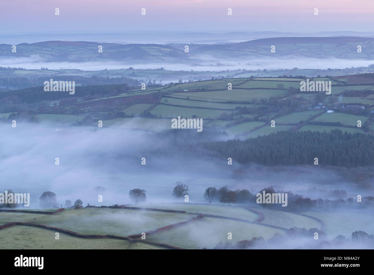 Misty hügelige Landschaft in der Morgendämmerung, Nationalpark Dartmoor, Devon, England. Winter (Dezember) 2017. Stockfoto