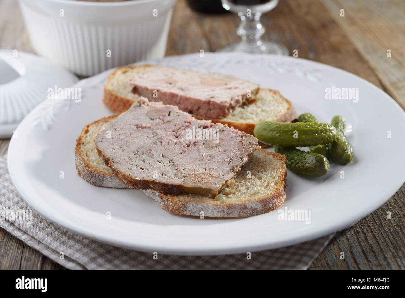 Sandwiches mit Terrine und Gurken auf einem Teller serviert Rith Rotwein Stockfoto