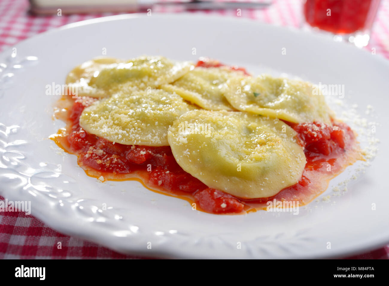 Spinat und Ricotta gefüllte Ravioli mit Tomatensauce und geriebenem ...