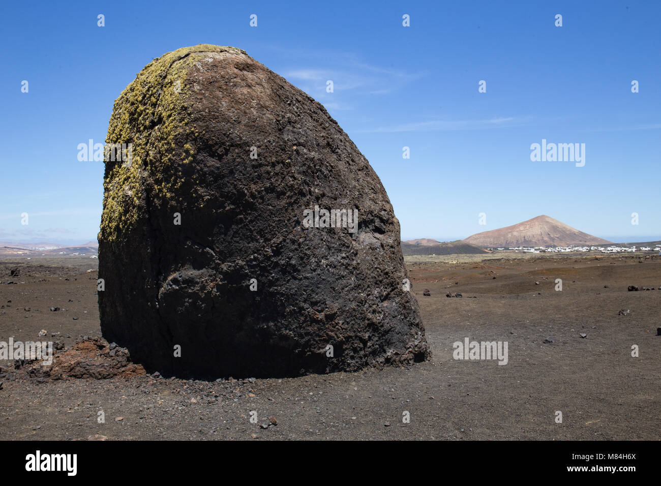 Große vulkanische Bombe, Lanzarote, Vulkankegel im Hintergrund Stockfoto
