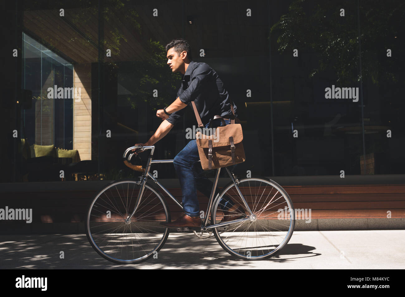 Geschäftsmann Kontrolle beim Radfahren in Büroräumen Stockfoto