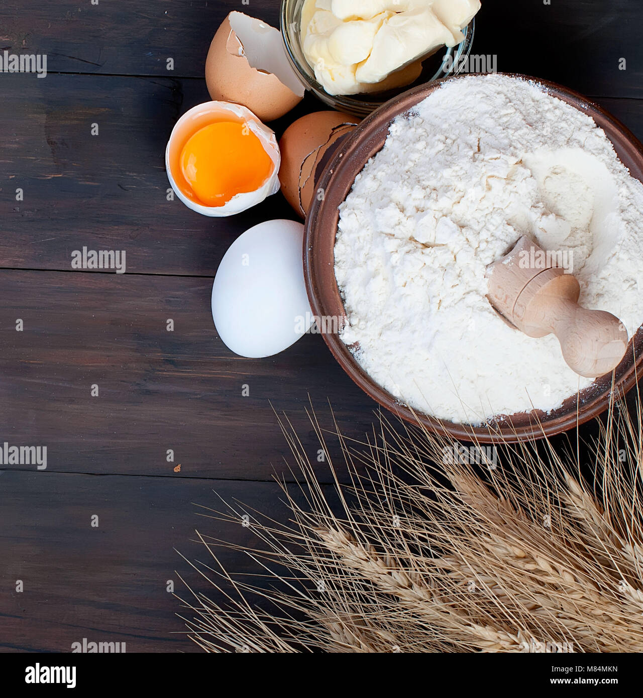 Hintergrund mit Backen backen Zutaten, Ohren, Ei, Eigelb, Shell, Mehl und Butter auf rustikalen Holzmöbeln, Ansicht von oben, Banner für Website kopieren spece Stockfoto