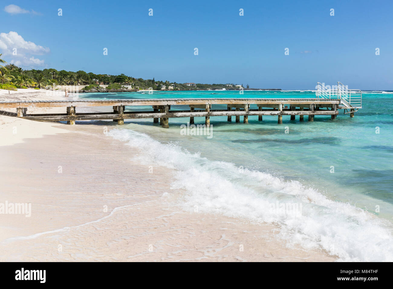 Eine hölzerne Seebrücke ragt in die Karibik am Spotts Beach in der Savanne auf der südlichen Seite von Grand Cayman, Cayman Islands Stockfoto