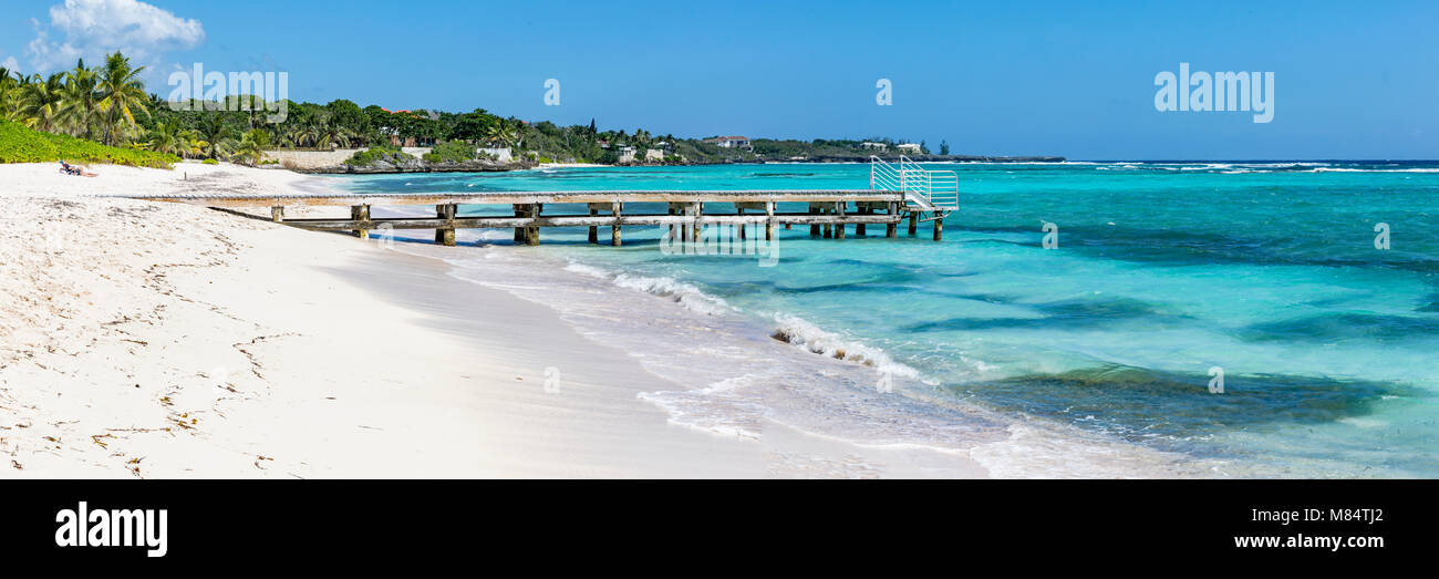 Eine hölzerne Seebrücke ragt in das türkisfarbene Wasser der Karibik am Spotts Beach in der Savanne, Grand Cayman, Cayman Islands Stockfoto