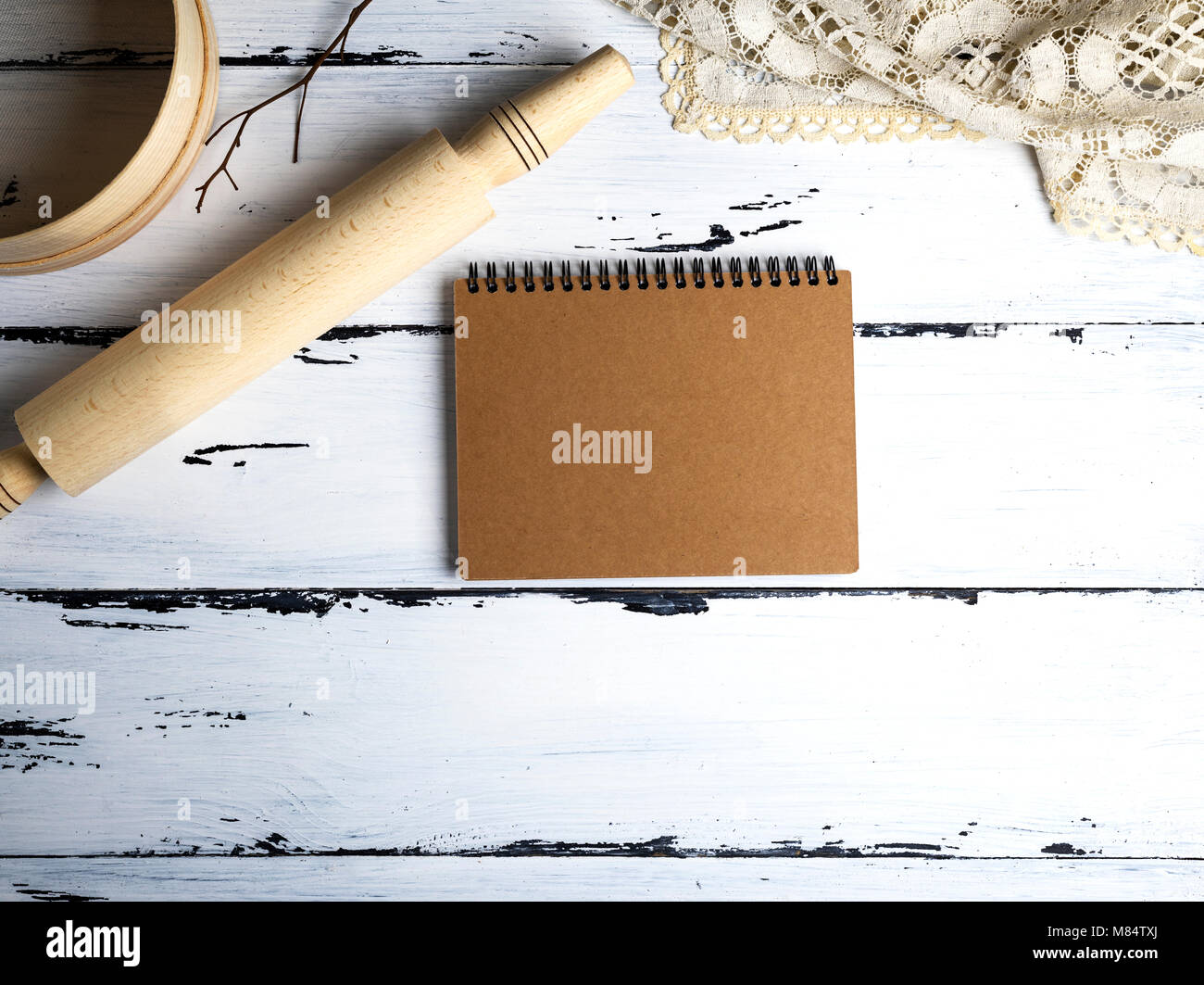 Leere Notepad, Holz- Rolling Pin und ein Sieb auf weißem Holz- Tabelle, Ansicht von oben Stockfoto