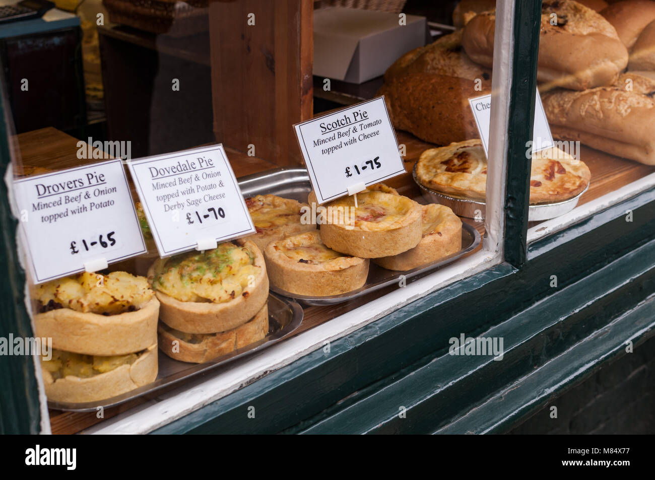 Eine Bäckerei Fenster mit verschiedenen Pasteten auf Anzeige für Verkauf, einschließlich dovedale Pie, Ashbourne, Peak District, Großbritannien Stockfoto