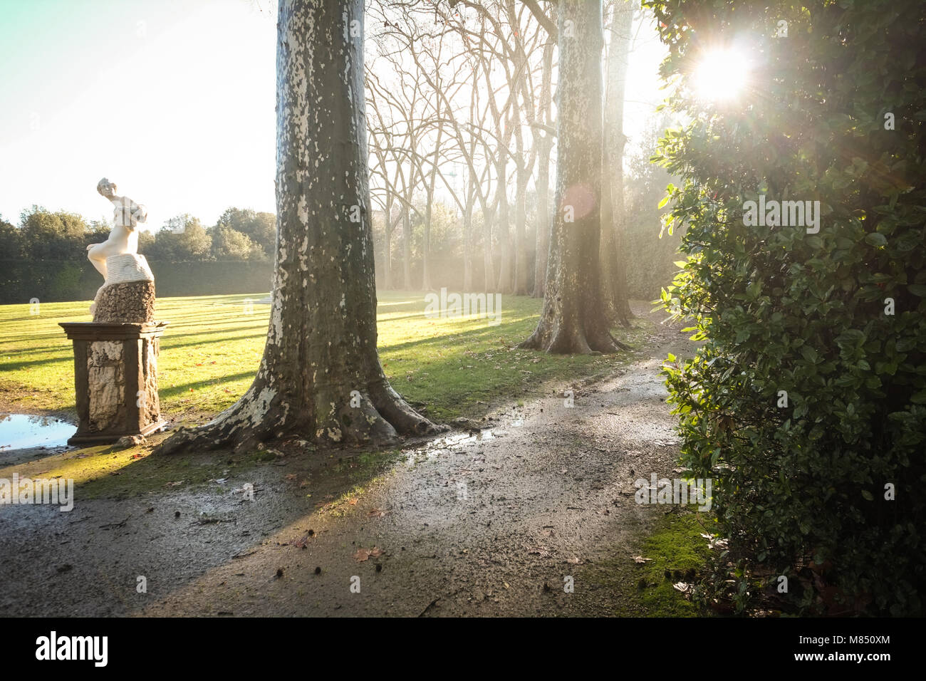 Eine Statue in einen italienischen Garten bei Sonnenuntergang mit Lens Flare. Stockfoto