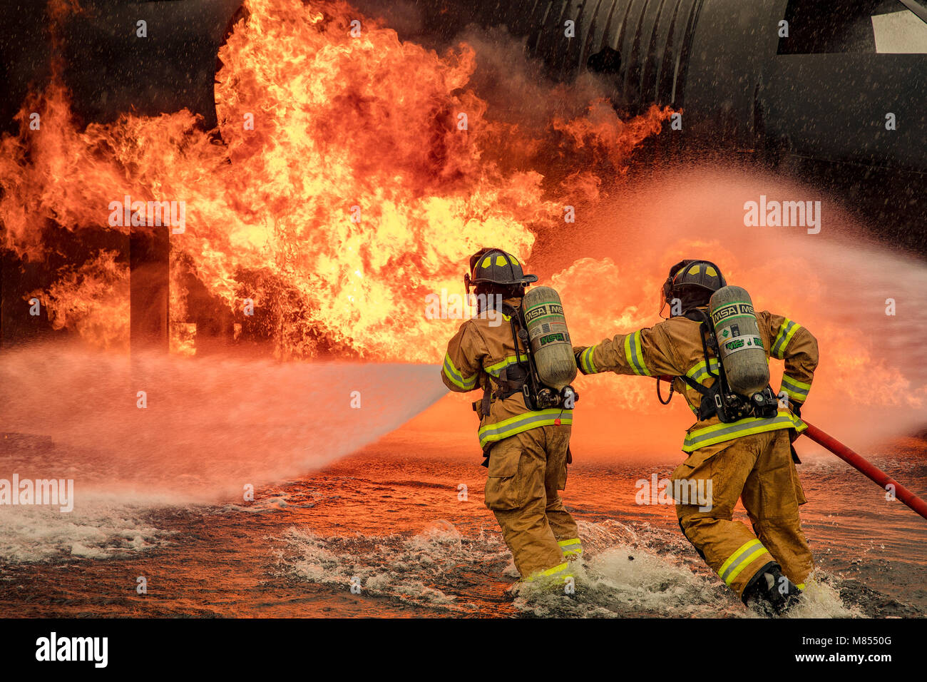 Ein mit zwei Personen Feuer Angriff Crew mit der 374 Bauingenieur Squadron Feuerwehr- und Rettungsdienste Flug, einen Strom von Wasser auf einer simulierten Flugzeugen Feuer an Yokota Air Base, Japan, 8. März 2018. Flugzeuge live Fire Training wird regelmäßig während des ganzen Jahres durchgeführt, Flieger und Zivilisten mit dem 374. und 374. Maintenance Squadron Reparatur und Aufarbeitung Abschnitt zu gewährleisten sind immer bereit, Flugkraftstoff Brände zu bekämpfen. (U.S. Air Force Foto von Yasuo Osakabe) Stockfoto
