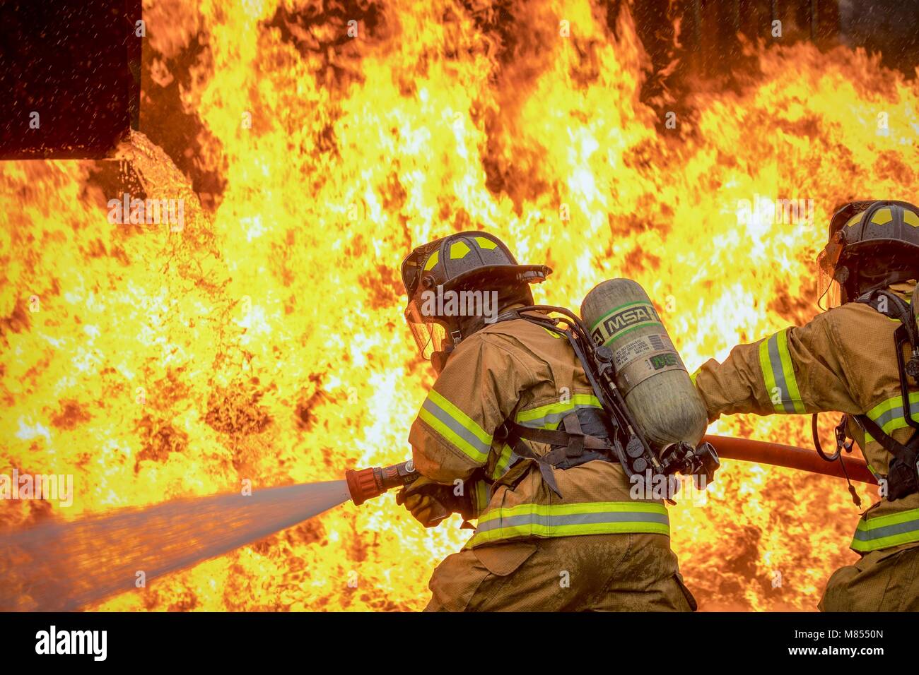 Ein mit zwei Personen Feuer Angriff Crew mit der 374 Bauingenieur Squadron Feuerwehr- und Rettungsdienste Flug Ziel ein Strom von Wasser auf einer simulierten Flugzeugen Feuer an Yokota Air Base, Japan, 8. März 2018. Flugzeuge live Fire Training wird regelmäßig während des ganzen Jahres durchgeführt, Flieger und Zivilisten mit dem 374. und 374. Maintenance Squadron Reparatur und Aufarbeitung Abschnitt zu gewährleisten sind immer bereit, Flugkraftstoff Brände zu bekämpfen. (U.S. Air Force Foto von Yasuo Osakabe) Stockfoto
