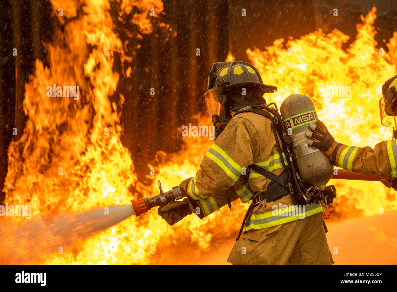 Ein mit zwei Personen Feuer Angriff Crew mit der 374 Bauingenieur Squadron Feuerwehr- und Rettungsdienste Flug, einen Strom von Wasser auf einer simulierten Flugzeugen Feuer an Yokota Air Base, Japan, 8. März 2018. Flugzeuge live Fire Training wird regelmäßig während des ganzen Jahres durchgeführt, Flieger und Zivilisten mit dem 374. und 374. Maintenance Squadron Reparatur und Aufarbeitung Abschnitt zu gewährleisten sind immer bereit, Flugkraftstoff Brände zu bekämpfen. (U.S. Air Force Foto von Yasuo Osakabe) Stockfoto