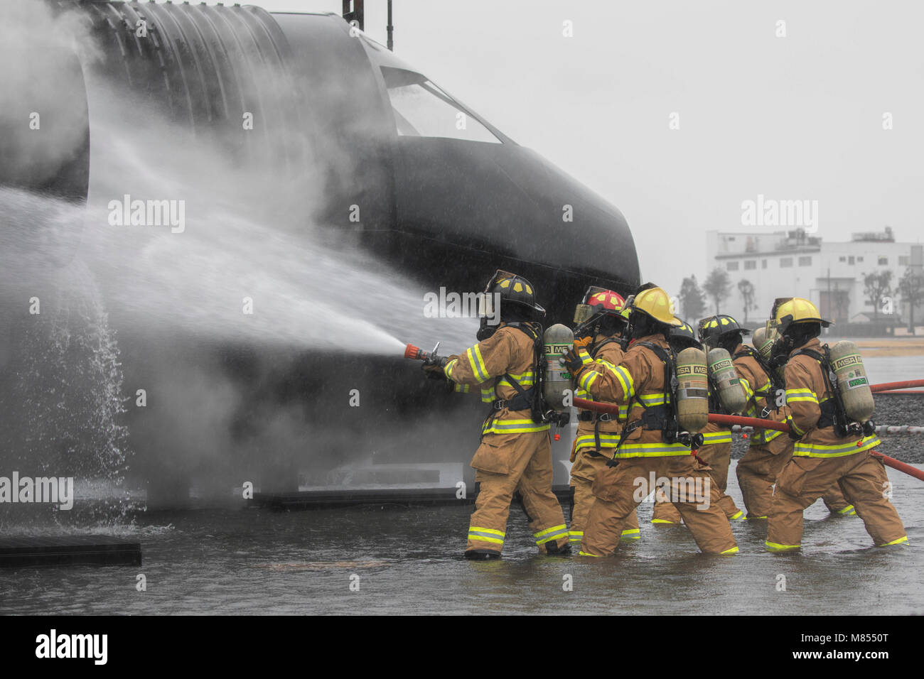 Feuerwehrmänner mit dem 374 Bauingenieur Squadron Feuerwehr- und Rettungsdienste Schlacht ein simuliertes Flugzeug ein Brand während einer Live-Fire Training bei Yokota Air Base, Japan, 8. März 2018. Flugzeuge live Fire Training wird regelmäßig während des ganzen Jahres durchgeführt, Flieger und Zivilisten mit dem 374. und 374. Maintenance Squadron Reparatur und Aufarbeitung Abschnitt zu gewährleisten sind immer bereit, Flugkraftstoff Brände zu bekämpfen. (U.S. Air Force Foto von Yasuo Osakabe) Stockfoto