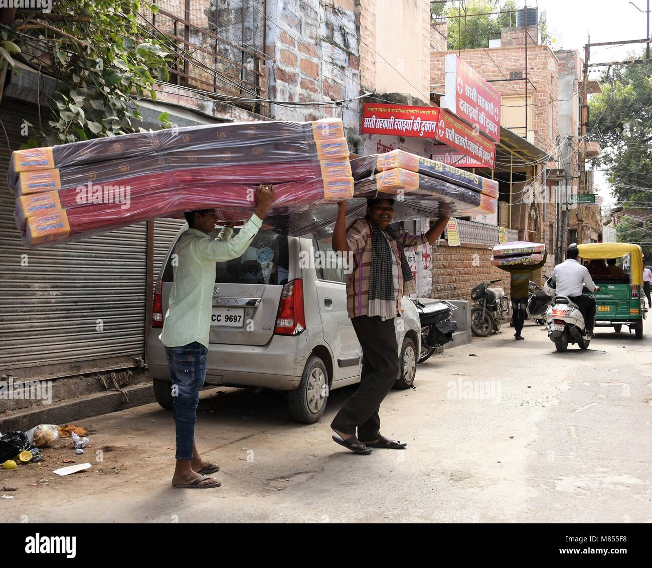 Indische Männer, die Matratzen durch die Straßen von Blue City trugen Stockfoto