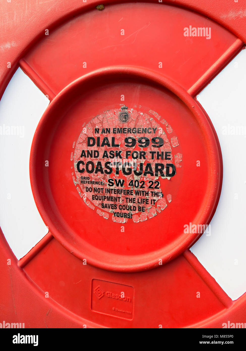 Alte verblasst und Peeling Notdienste Label auf rettungsring Gehäuse, Penberth Cove Harbour, Cornwall, England, Großbritannien Stockfoto