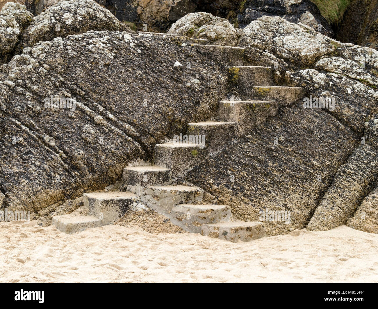 Konkrete Schritte auf den Pfad von Porthcurno Strand über Felsen und Klippen Richtung Minack Theatre, Cornwall, England, Großbritannien Stockfoto