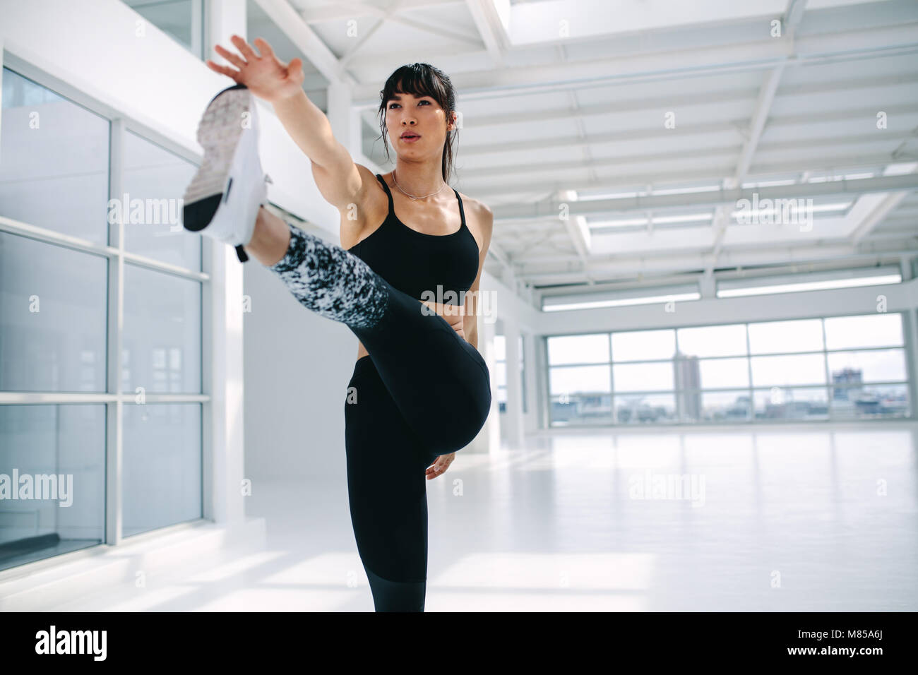 Passende Frau praktizieren von Yoga. Frauen stehen im Erweiterten hand Zehengriff im Fitness Studio. Stockfoto