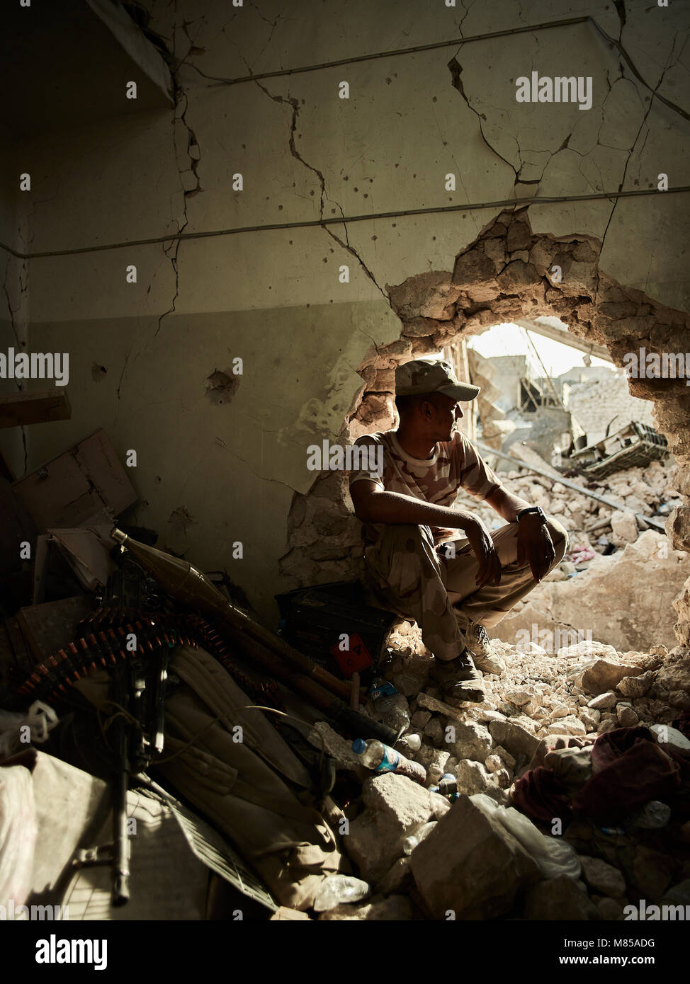 Ein irakischer Soldat wacht durch ein Loch an seine Spitzenposition. Die Stadt Mosul im Nordirak hat unter islamischen Staat militanten wurde für 3 Jahre, seit Juni 2014. Im Juli 2017 die Streitkräfte der Koalition geführt von der irakischen Armee hat endlich befreit die Stadt aus der Hand von Terroristen. Stockfoto