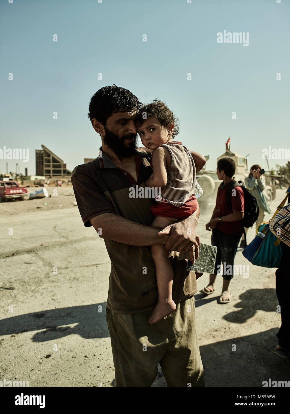 Ein Vater und eine Tochter warten für einen Krankenwagen an einem Kontrollpunkt in Mossul. Die Stadt Mosul im Nordirak hat unter islamischen Staat militanten wurde für 3 Jahre, seit Juni 2014. Im Juli 2017 die Streitkräfte der Koalition geführt von der irakischen Armee hat endlich befreit die Stadt aus der Hand von Terroristen. Stockfoto