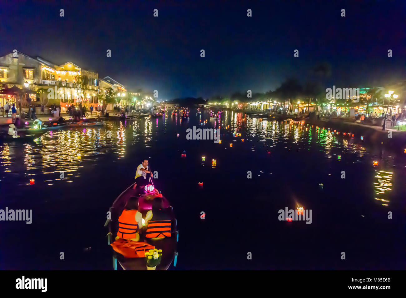 Dutzende von bunten schwimmende Kerzen schwimmen den Fluss hinunter in Hoi An, Vietnam Stockfoto