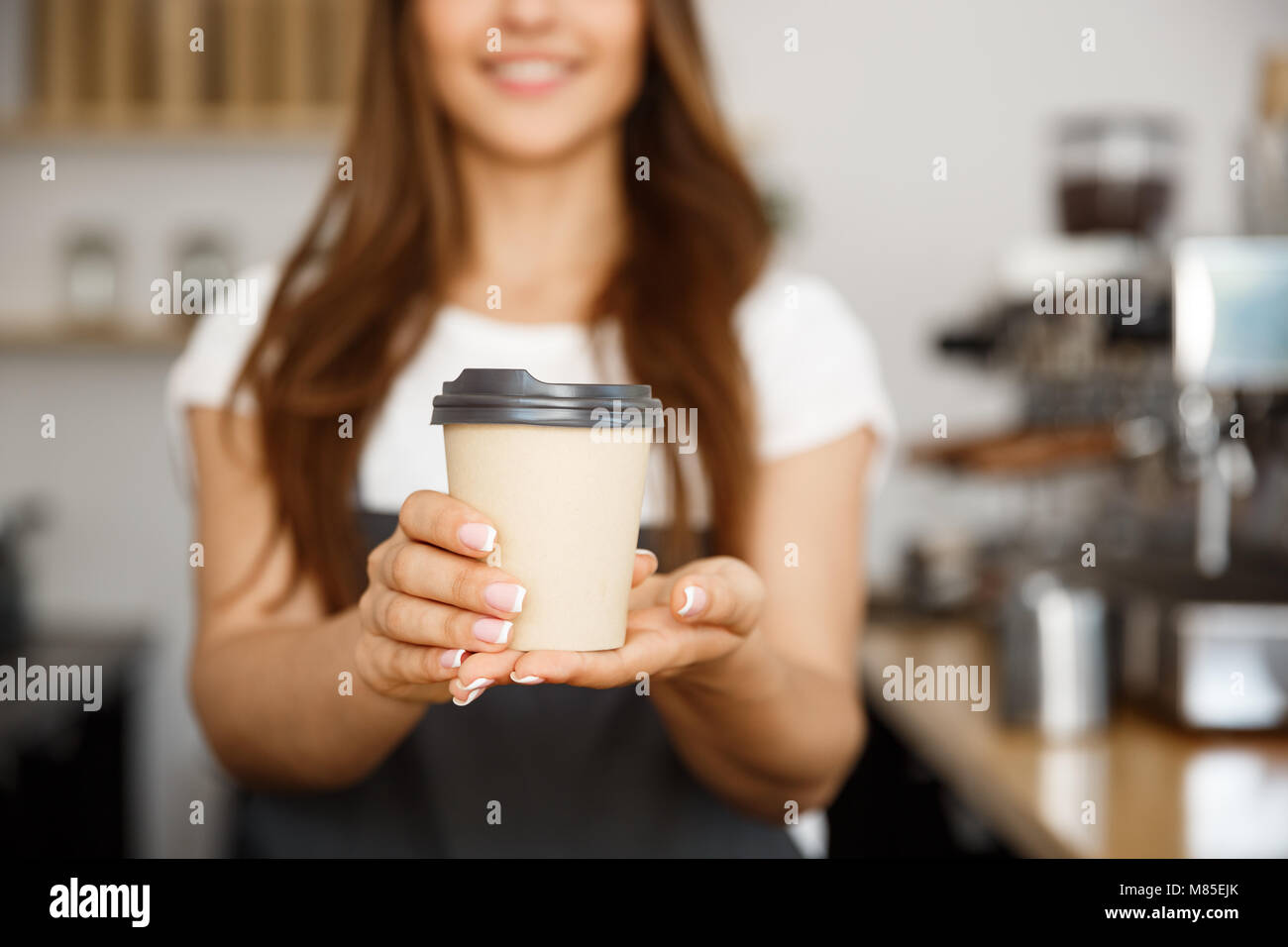 Kaffee Geschäftskonzept - Schöne kaukasischen Dame lächelte Kamera bietet Einweg entfernt heißen Kaffee in der modernen Coffee Shop nehmen Stockfoto