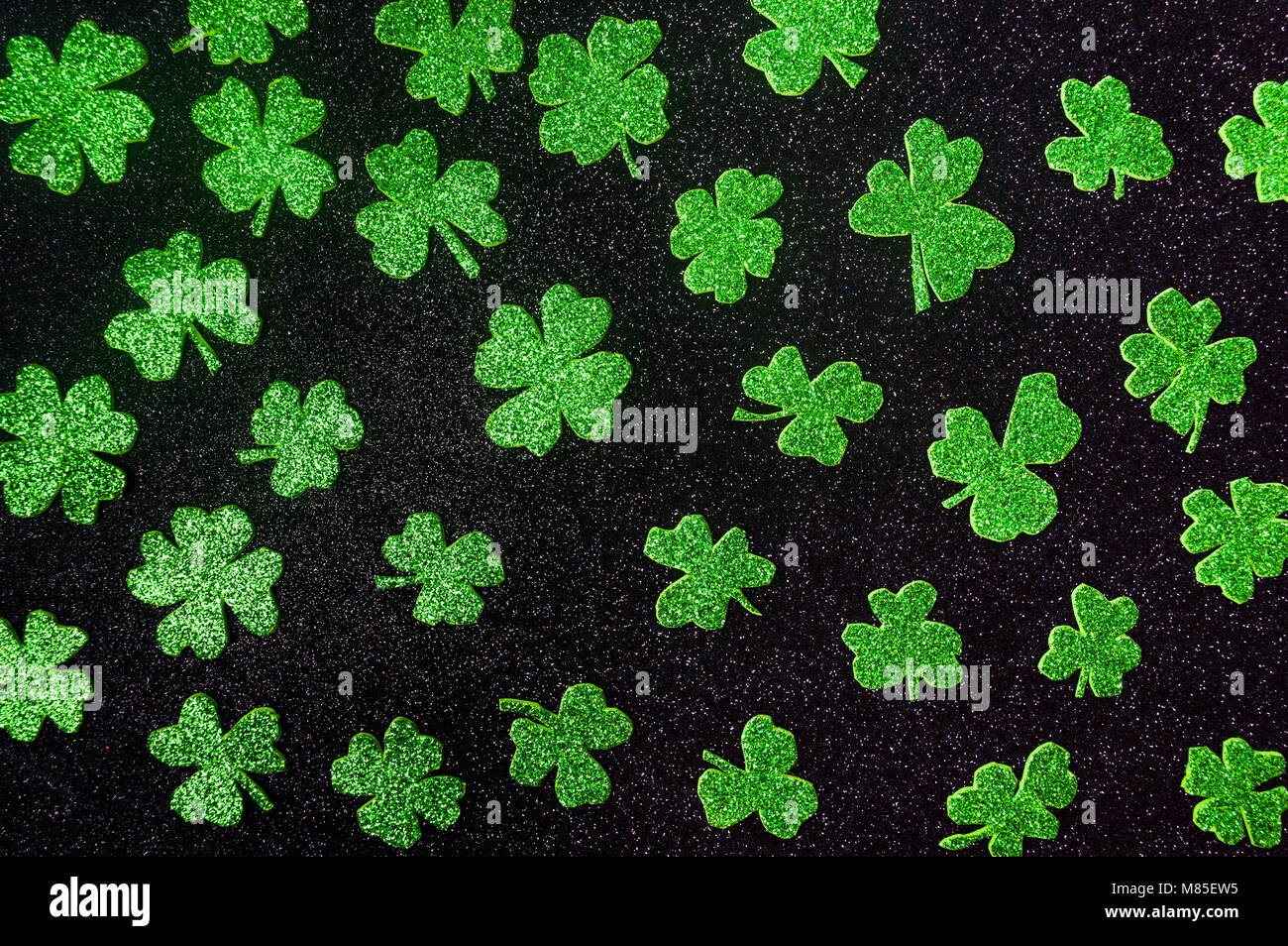 Glitzernde grüne Kleeblätter Hintergrundmuster flach Stockfoto