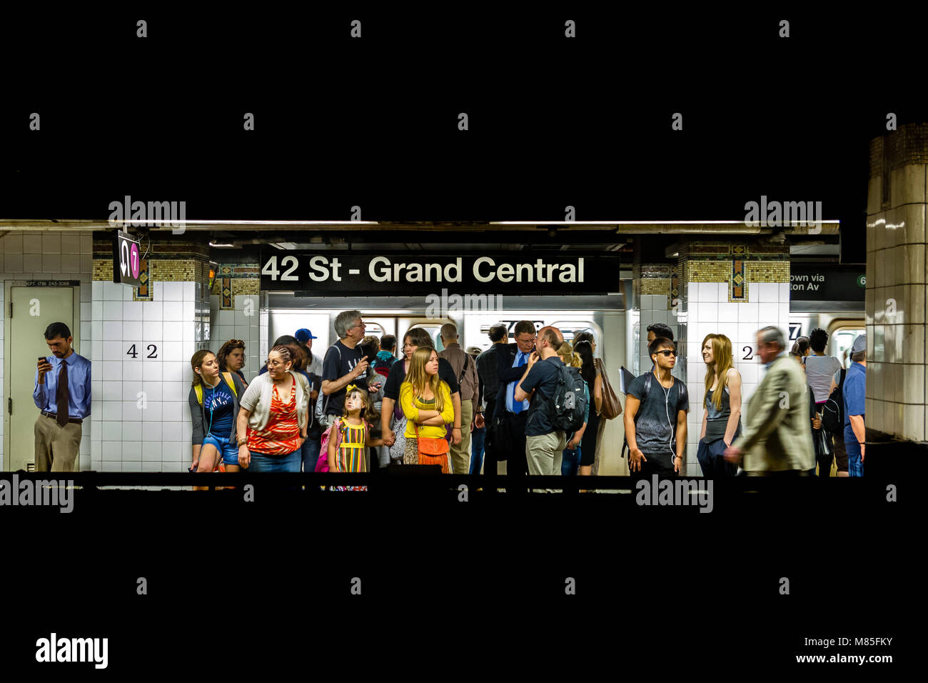 Die Menschen auf der Warteliste für eine U-Bahn an der 42nd Street, New York City Stockfoto