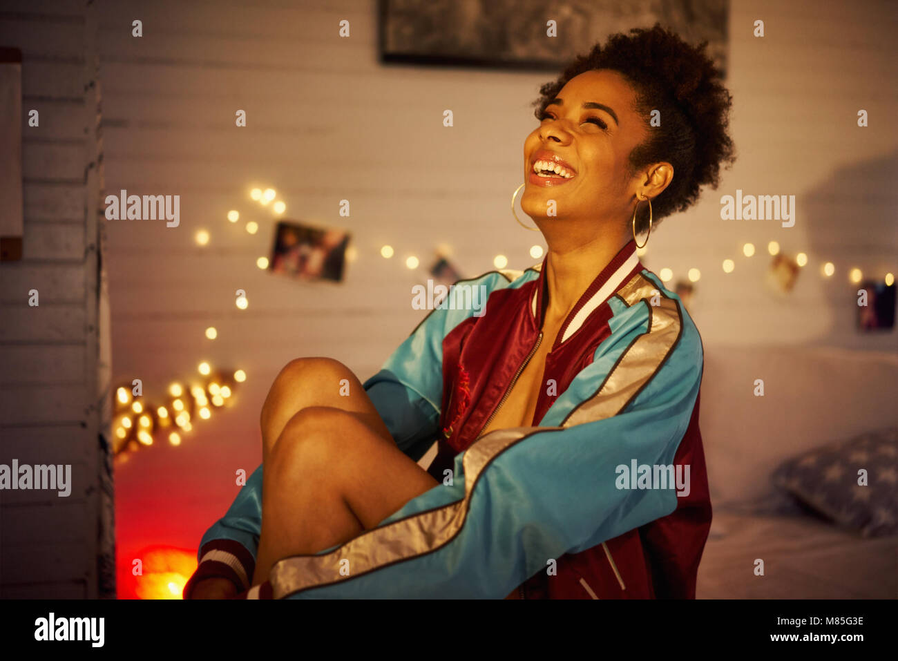 Junge Fröhliche schwarze Frau lächelnd bei Nacht Stockfoto