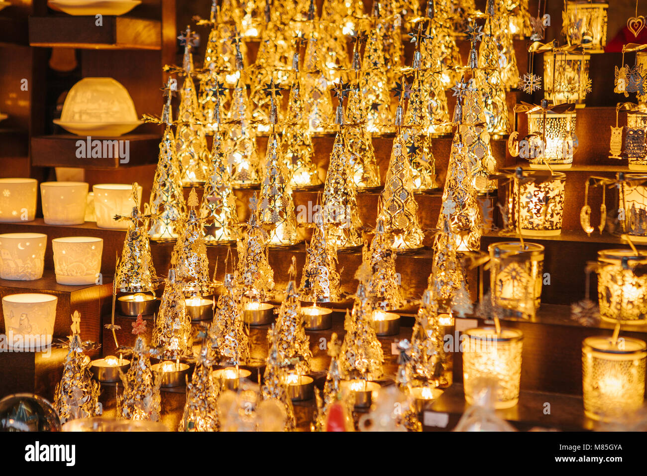 Close-up-Showcase im Store mit schönen Souvenirs - brennende Weihnachtsbeleuchtung in Form von Xmas Bäume und Gläser Stockfoto
