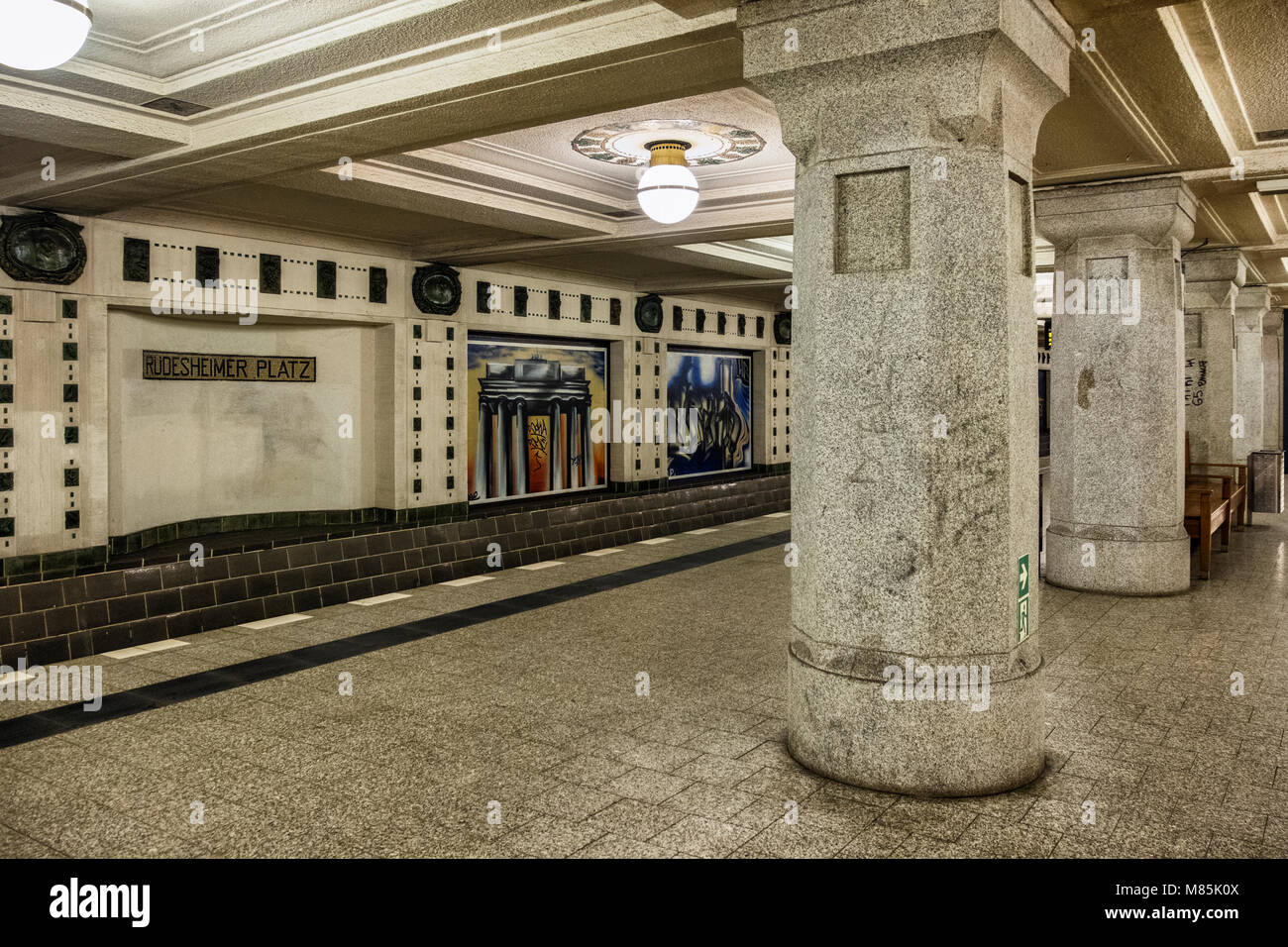 Berlin Wilmersdorf. Rüdesheimer Platz U-Bahn U3 U-Bahnhof Interieur & Plattform, Granit Säulen, braunen Fliesen, lebendige Bilder an der Wand Stockfoto