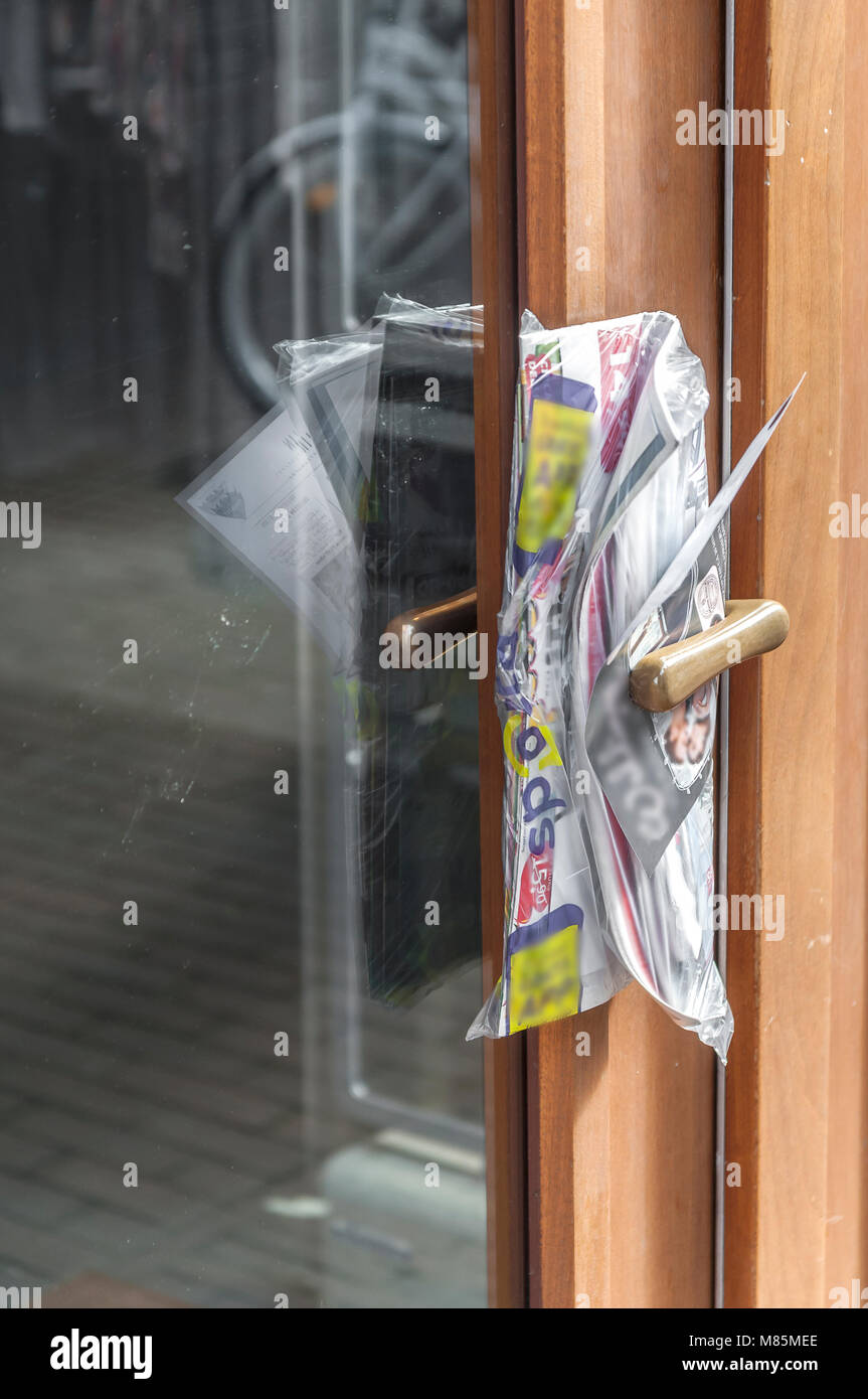 Werbebroschüren zwischen Tür geklemmt Griff einer Tür Stockfoto