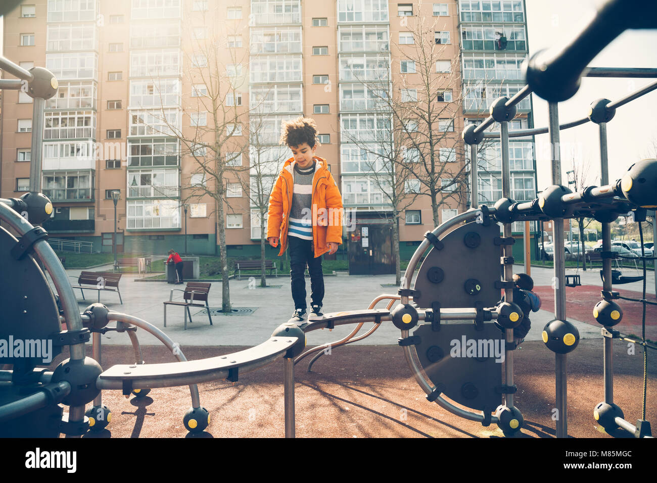 Cute little boy gehen die Balance bar in einem städtischen Spielplatz an einem sonnigen Tag Stockfoto