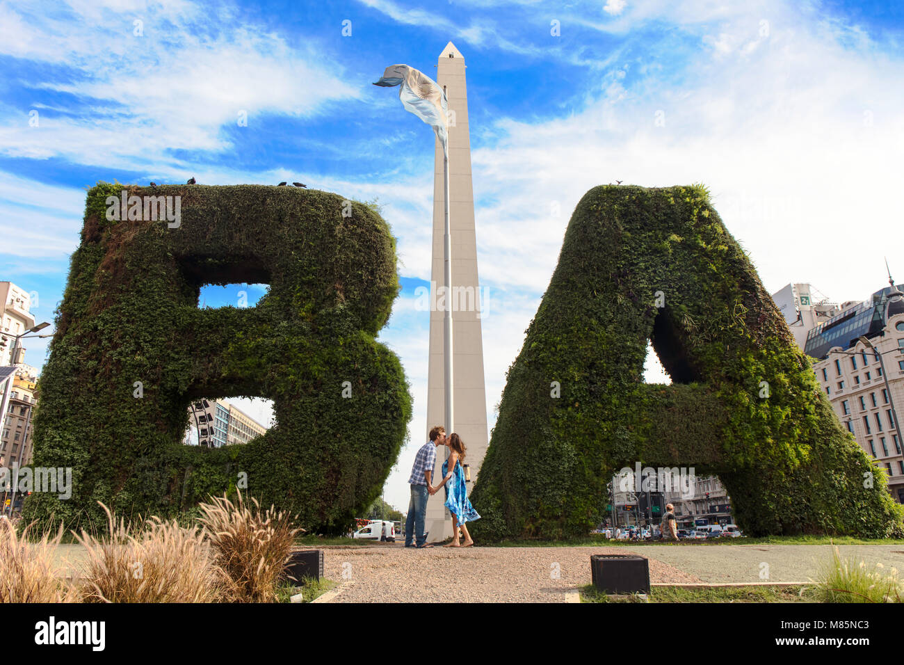 Ein paar touristische Küssen vor der Obelisk Denkmal auf der Avenida 9 de Julio. Buenos Aires, Argentinien. Stockfoto