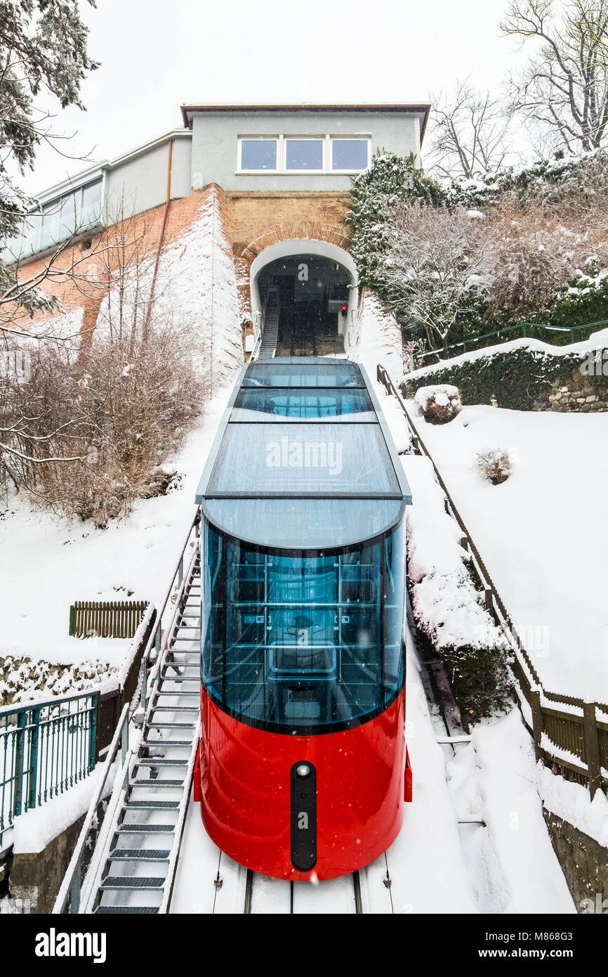 Rote Standseilbahn Cable Car fahrt zu Berg Stadion auf Schnee im Winter Berg Schlossberg in der Stadt Graz Stockfoto