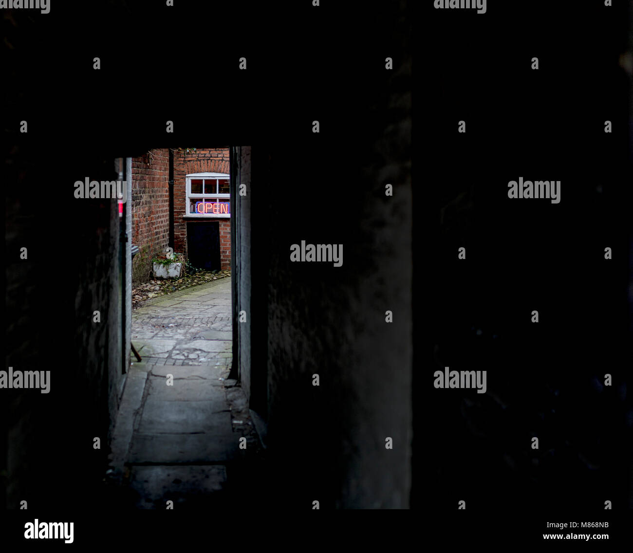 Unheimlich und gruselig dunkel brick Gasse oder versteckte Passage, die zum Licht und eine Neon"-Schild Stockfoto