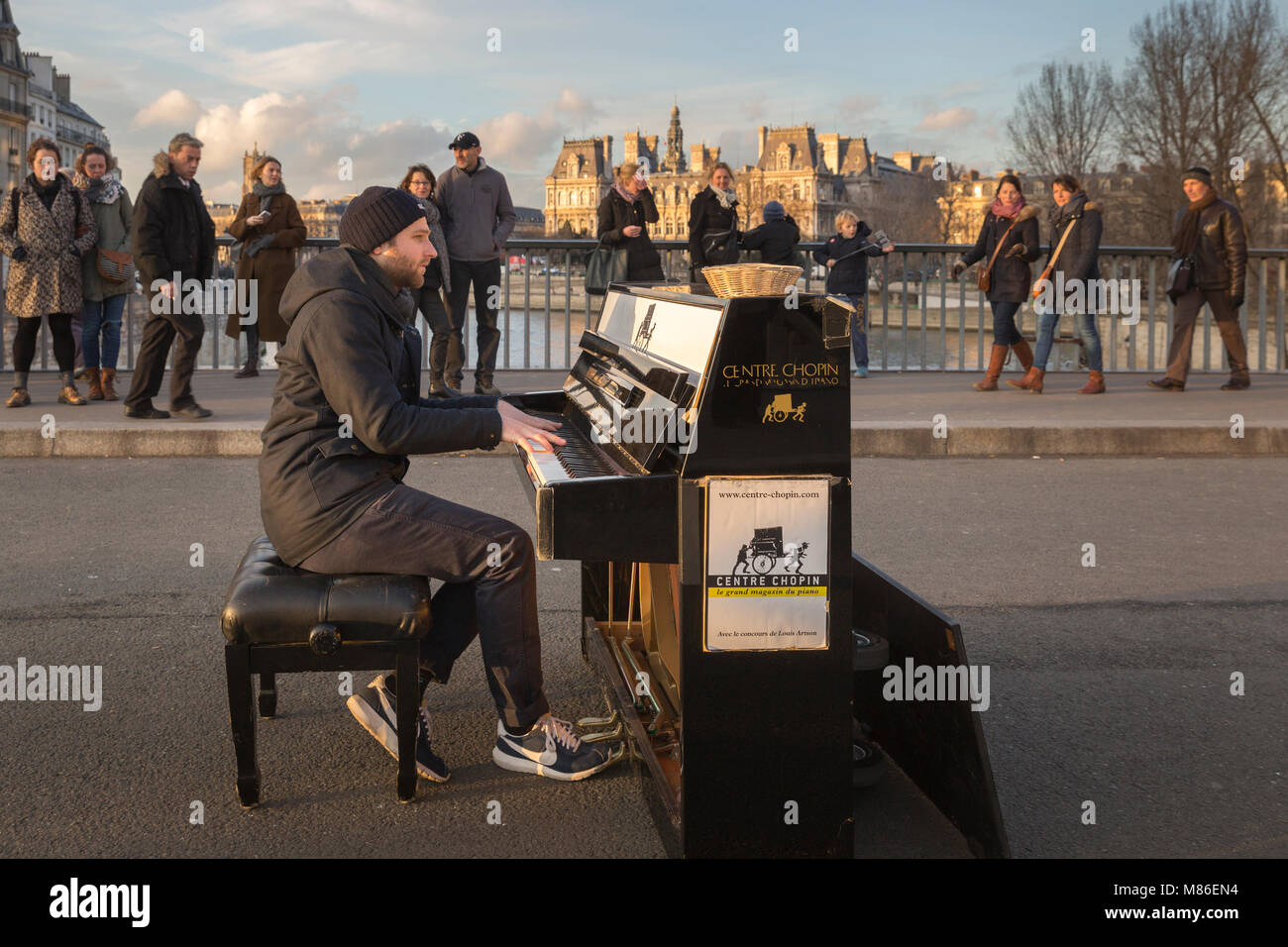 Straße muscian Louis Artson spielen ein Klavier auf Pont Saint Louis in Paris, Frankreich. Werbung auf der Seite des Klaviers ist für das Zentrum Chopin Pian Stockfoto