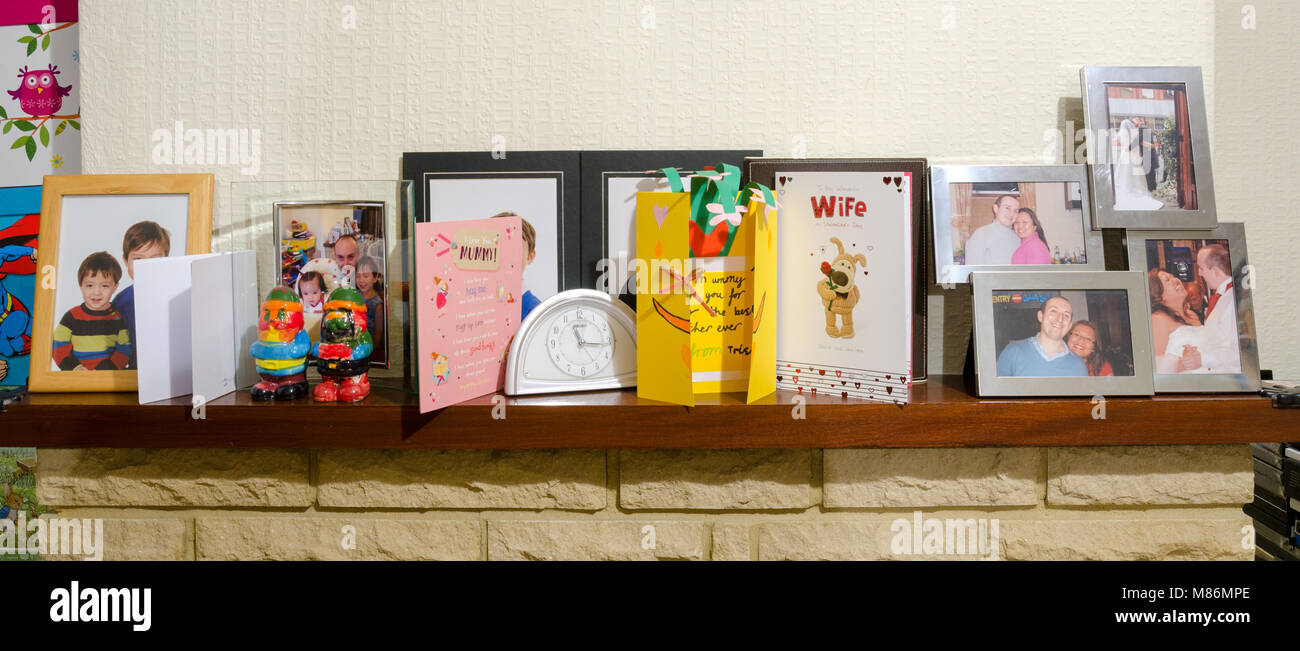 Ein Kamin mit einer Uhr, Familie Fotos und Muttertag Karten. Stockfoto