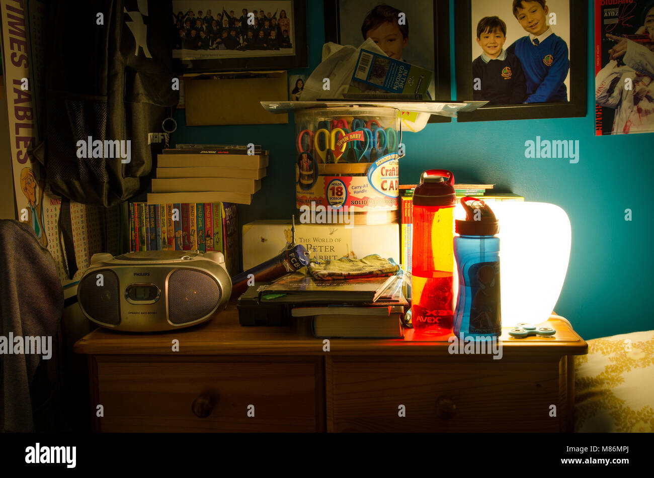 Ein Nachttisch Kommode, in der ein Junge Schlafzimmer, beleuchtet durch eine Lampe in der Nacht. Stockfoto