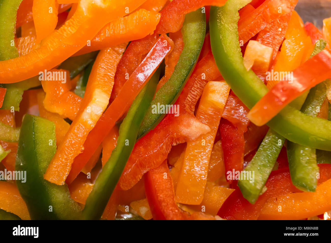 Die frische rote, orange und grüne Paprika in Scheiben geschnitten fertig gekocht zu werden Stockfoto