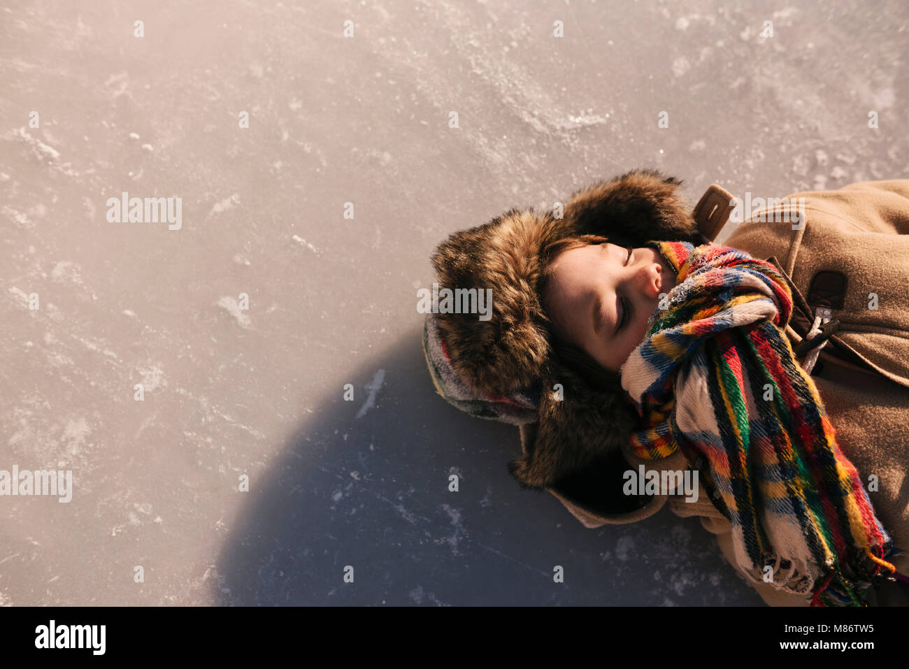 Junge lag auf einem zugefrorenen See Stockfoto