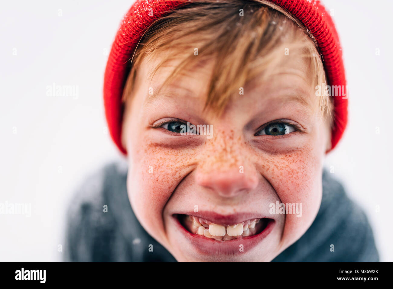 Porträt eines Jungen mit Sommersprossen ziehen lustige Gesichter Stockfoto