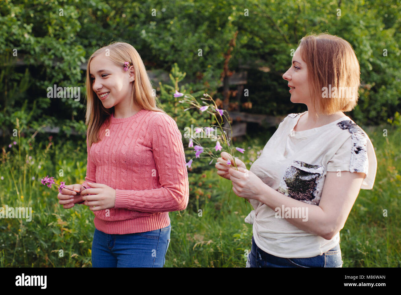 Mutter und Tochter Blumen pflücken in einem Garten Stockfoto