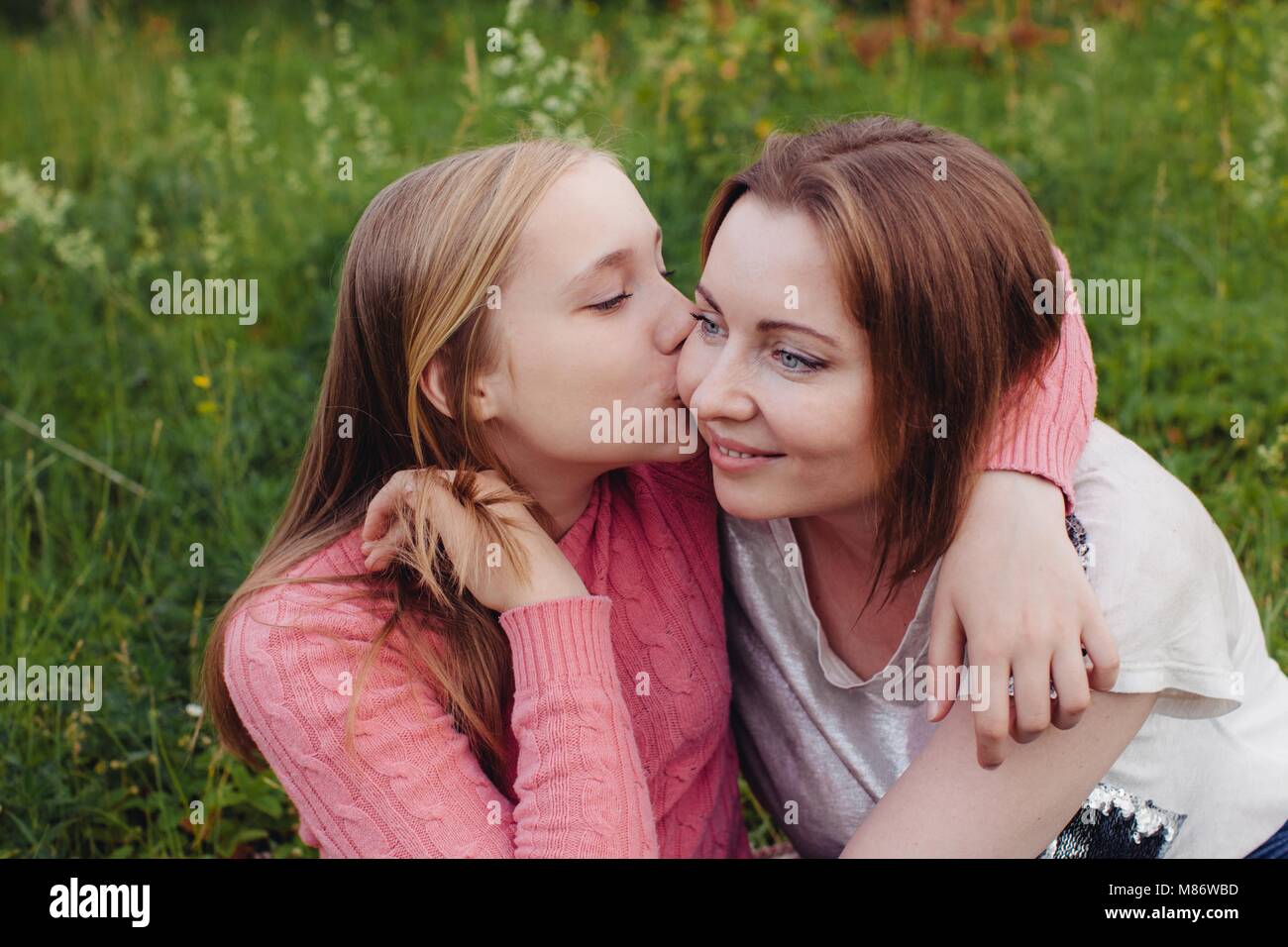 Tochter umarmen und küssen ihre Mutter Stockfoto