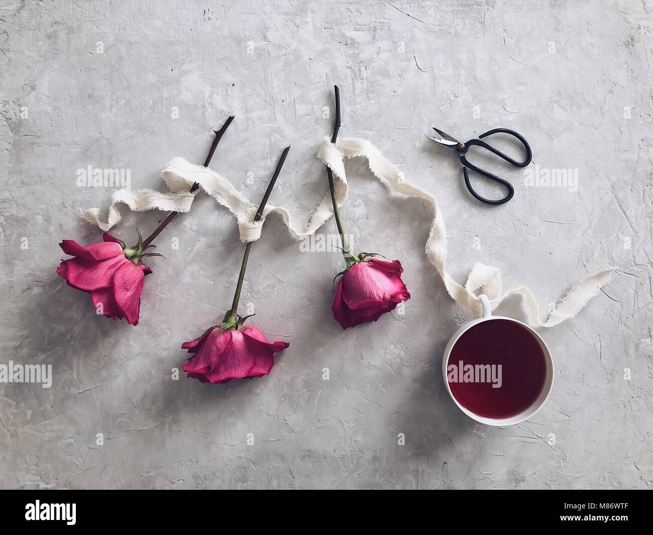 Drei Rosen und eine Tasse Kräutertee Stockfoto