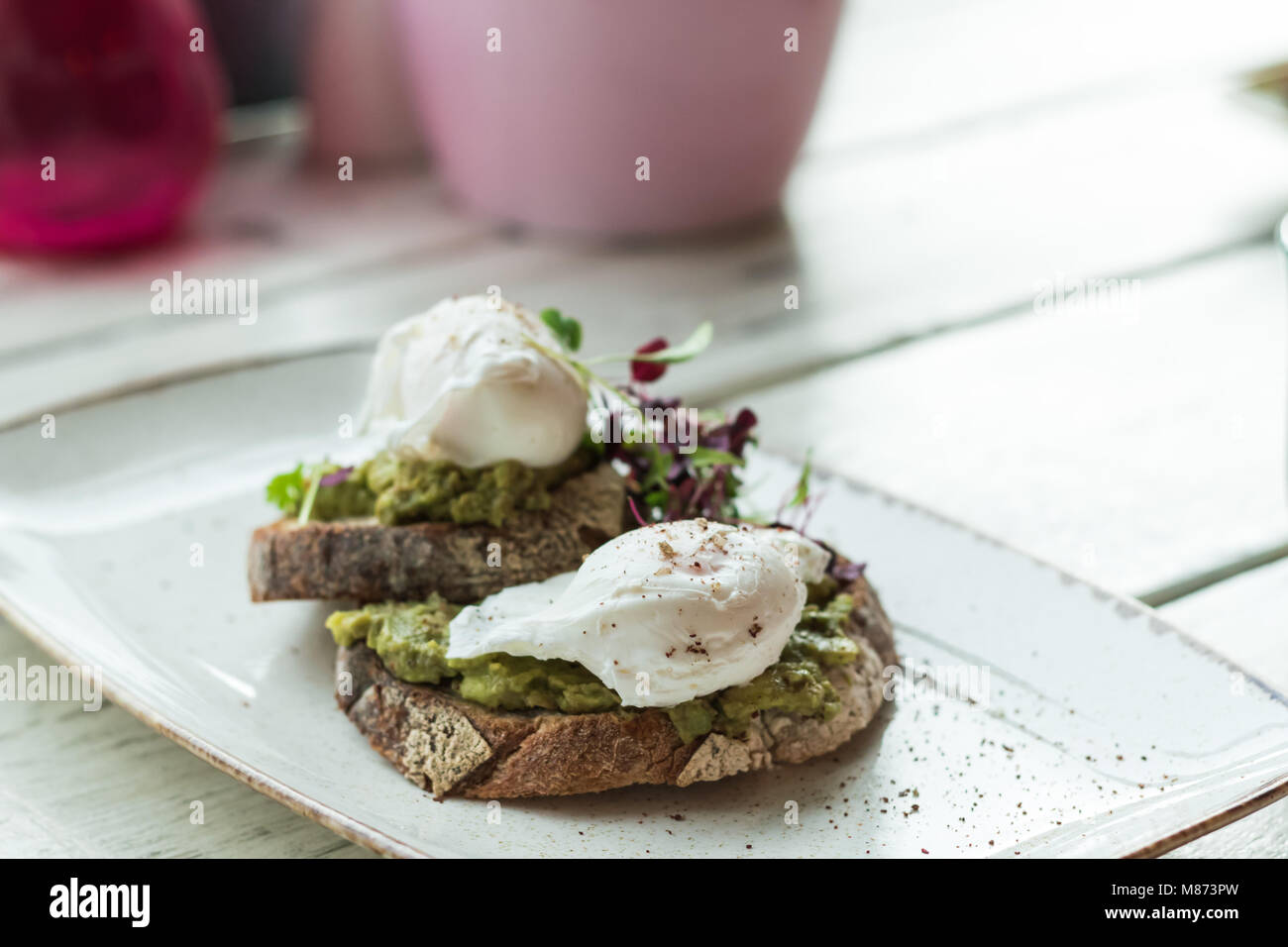Pochierte Eier und Avocado auf Toast Frühstück Stockfoto