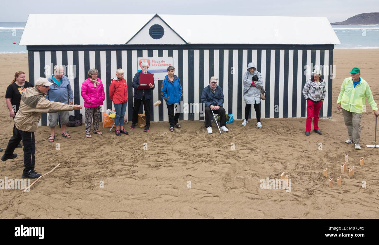 Ältere Finnen spielen mölkky (eine Kegelbahn Spiel populär in Finnland) am Strand Las Canteras in Las Palmas, Gran Canaria, Kanarische Inseln, Spanien Stockfoto