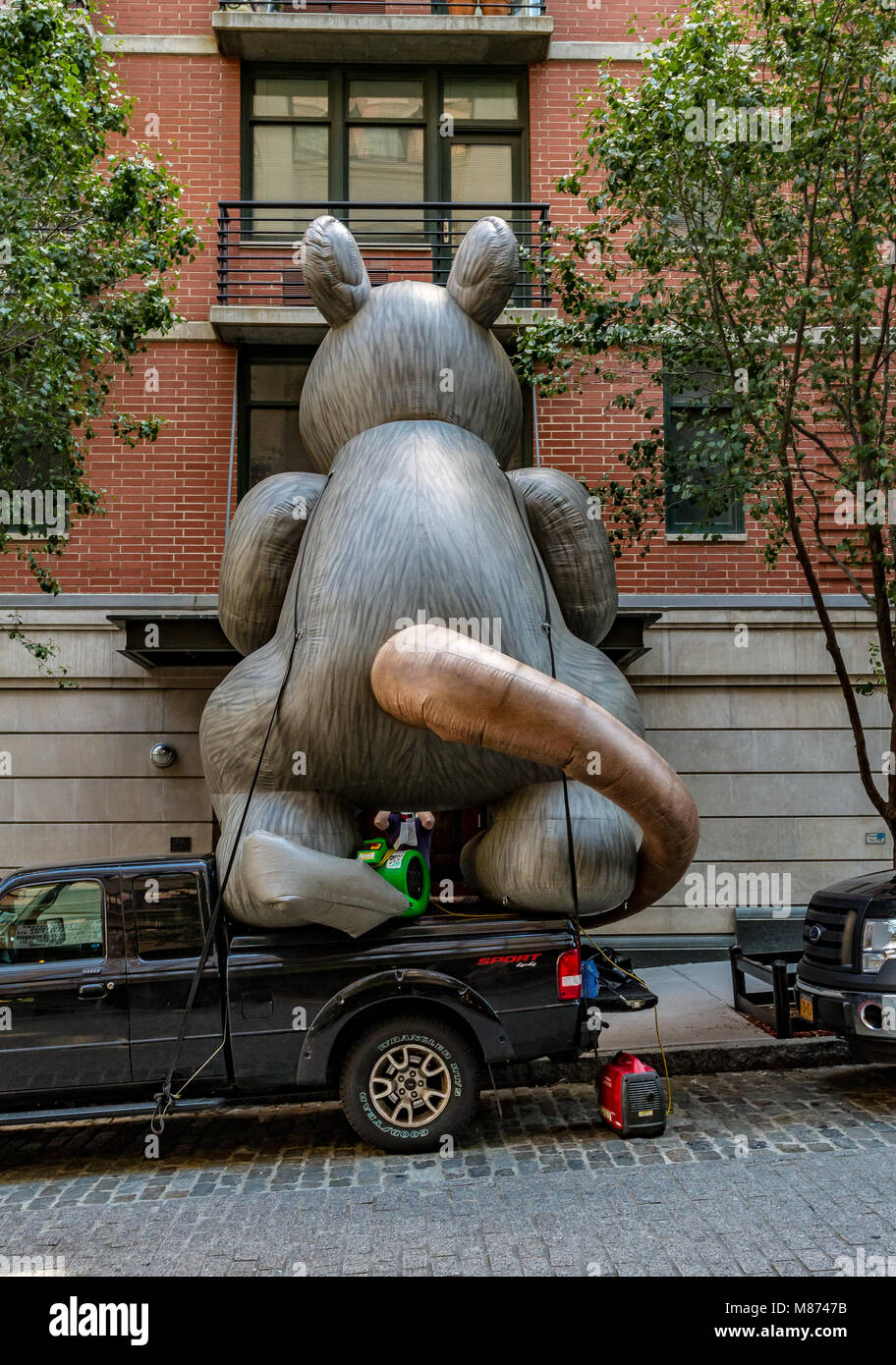 Riesigen aufblasbaren Nagetier auf der Rückseite eines Auto sieht durch ein Fenster in eine Wohnung, Brooklyn, New York Stockfoto